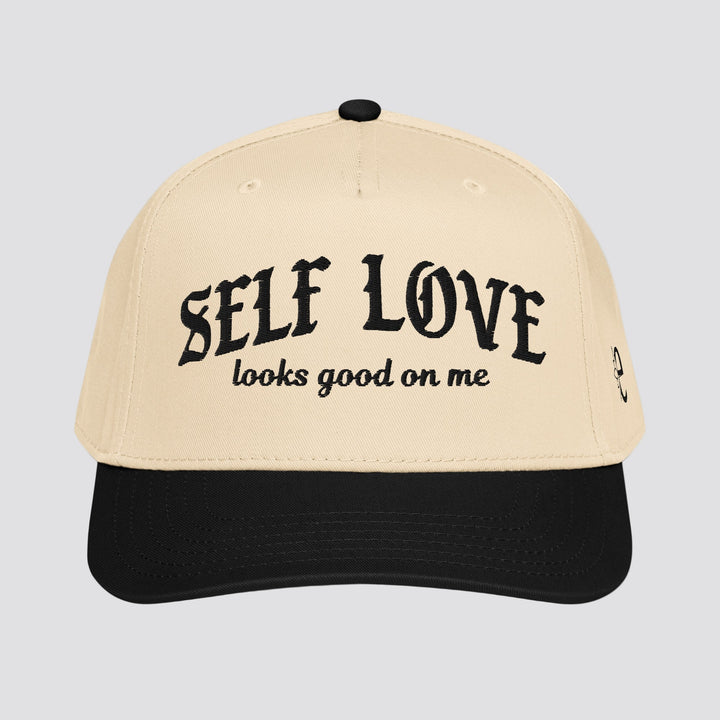 Beige and black cap with 'SELF LOVE looks good on me' text on a white background
