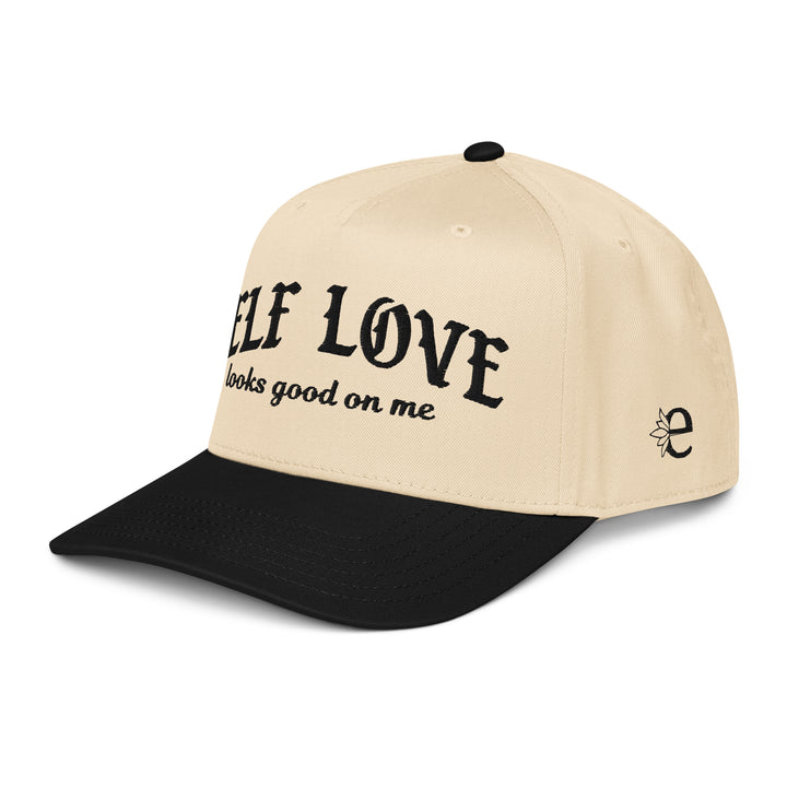 Beige and black cap with 'Self Love looks good on me' text on a white background