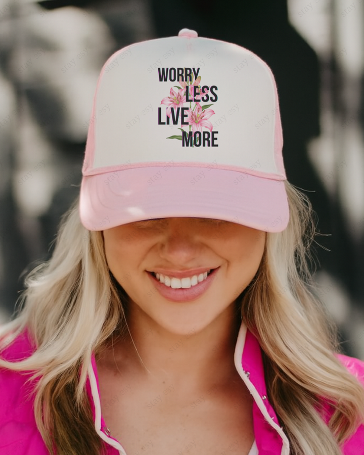 Person wearing a pink and white cap with motivational text and flowers.