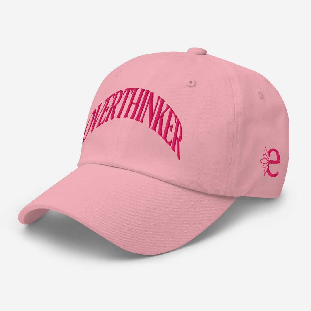 Pink cap with 'OVERTHINKER' text on a light gray background