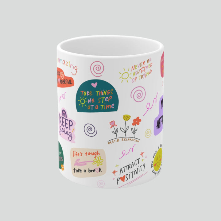 White ceramic mug featuring inspirational daily affirmations, perfect for morning coffee ritual and self-care routine