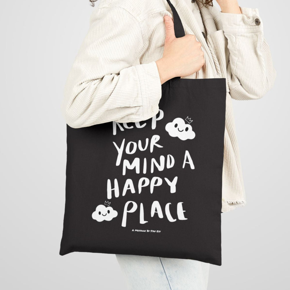 Woman holding a black tote bag with text on a plain background