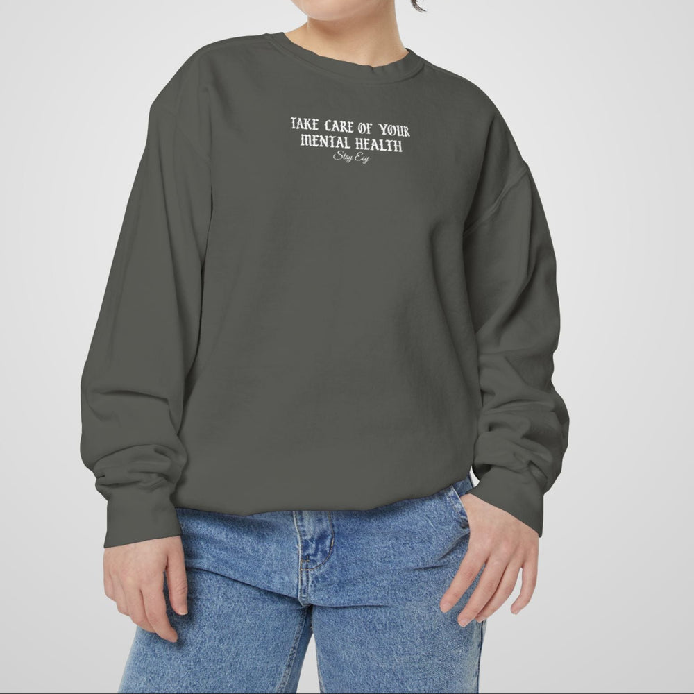 Person wearing a gray sweatshirt with text on a plain background