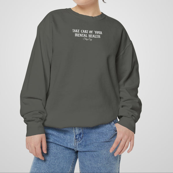 Person wearing a gray sweatshirt with text on a plain background