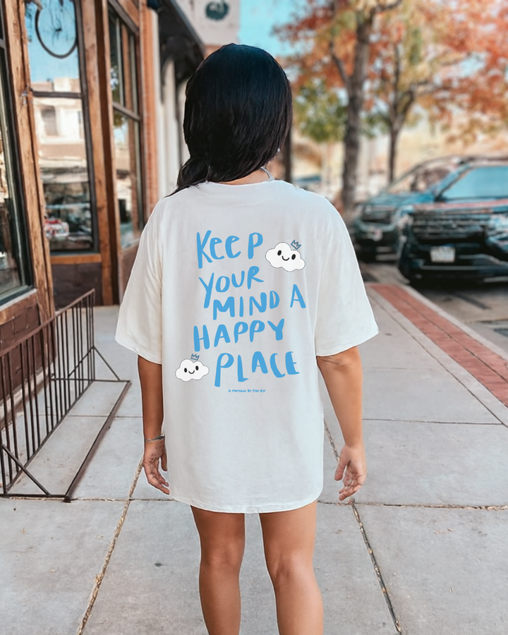 Person wearing a white t-shirt with a motivational quote on the back, standing on a sidewalk.