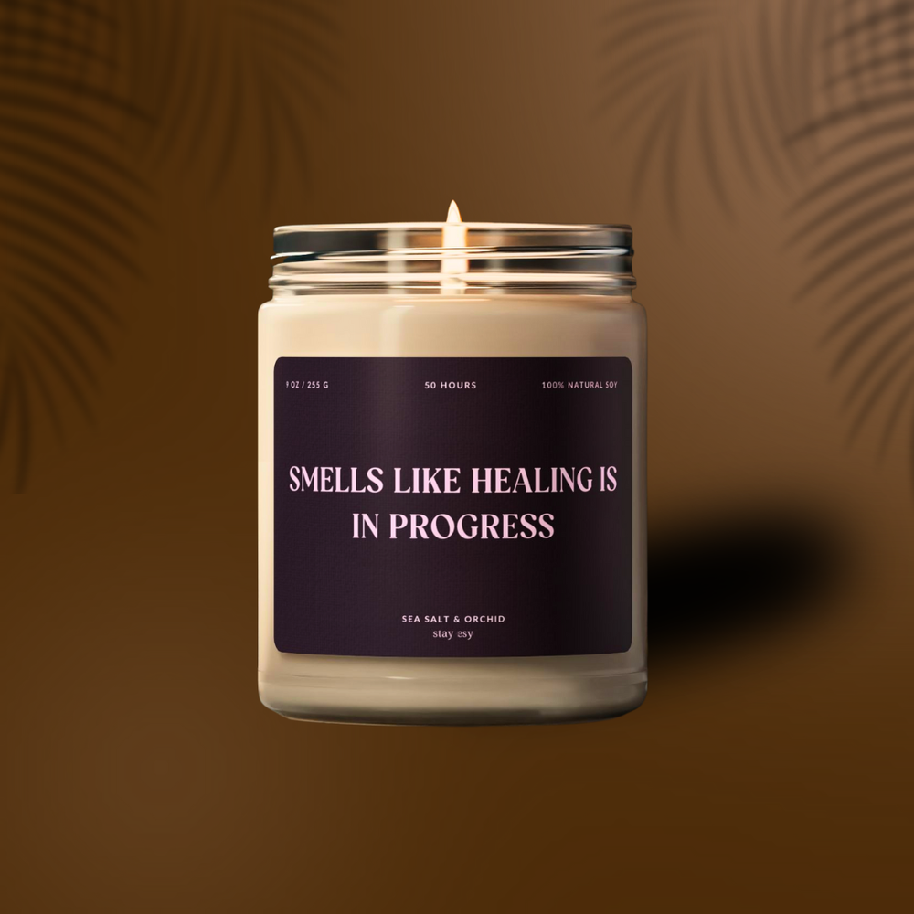Candle in a glass jar with a purple label on a brown background