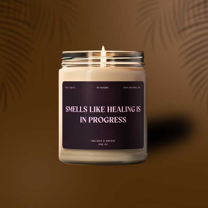 Candle in a glass jar with a purple label on a brown background