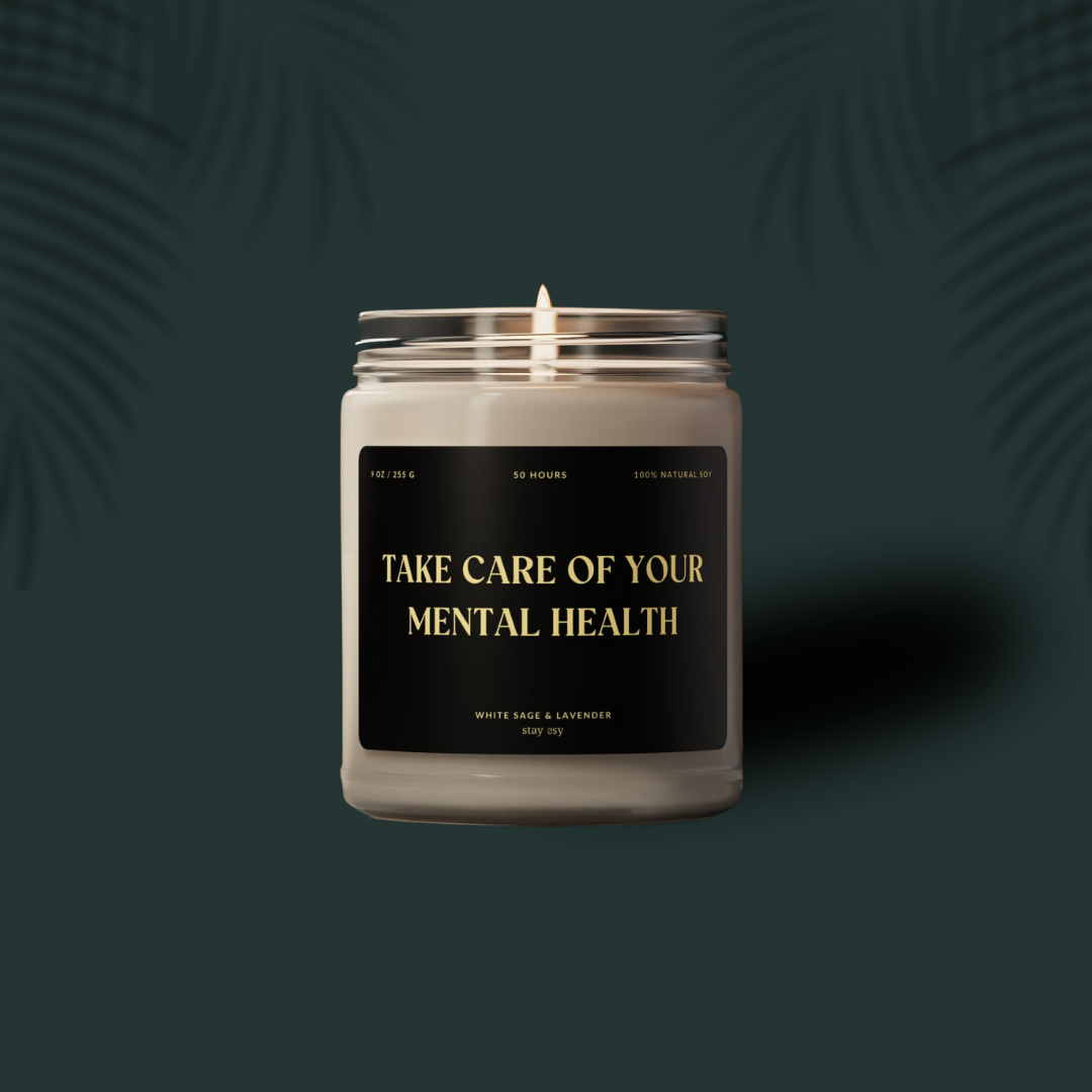 Candle in a glass jar with a label on a dark green background