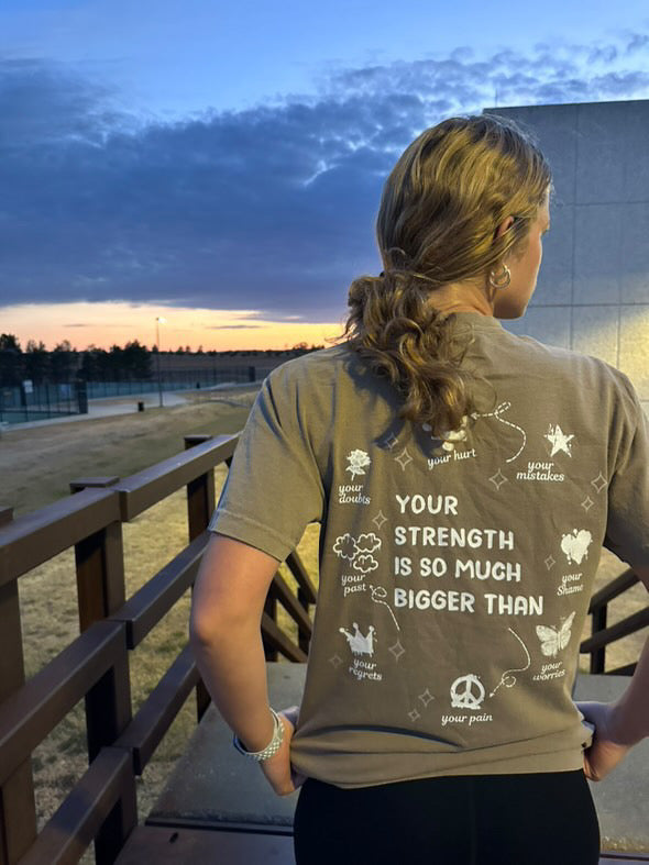 Person wearing a t-shirt with motivational text at sunset