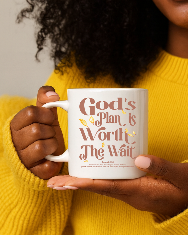 Person holding a mug with 'God's Plan is Worth the Wait' text