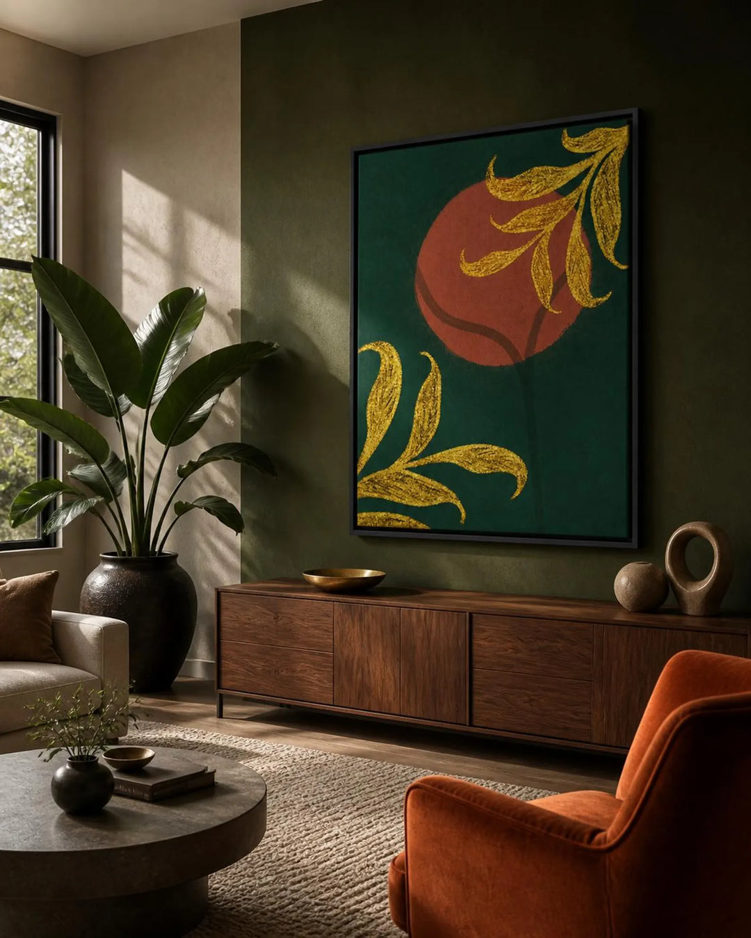 A framed vertical wall art print featuring a dark green background with a large terracotta orange circle and gold leafy branches, displayed in a modern living room setting above a wooden console table.