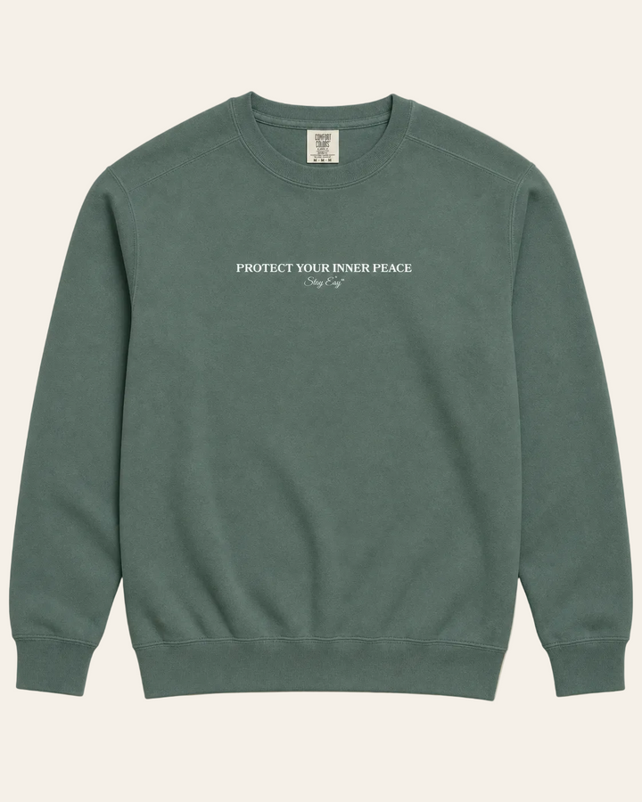 Green Unisex sweatshirt with "Protect Your inner Peace" text on a beige background