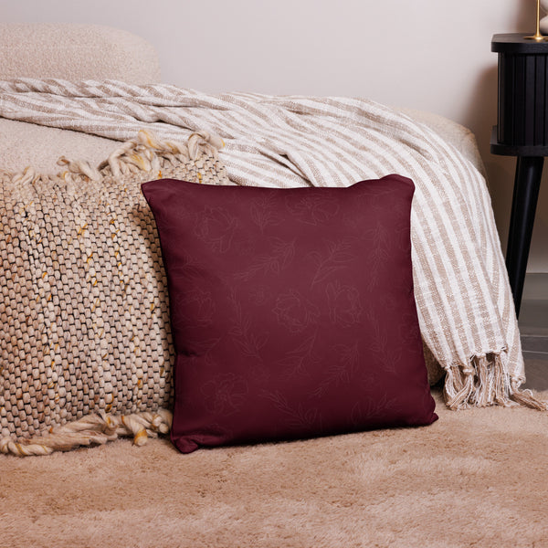 Maroon pillow with floral pattern on a textured surface