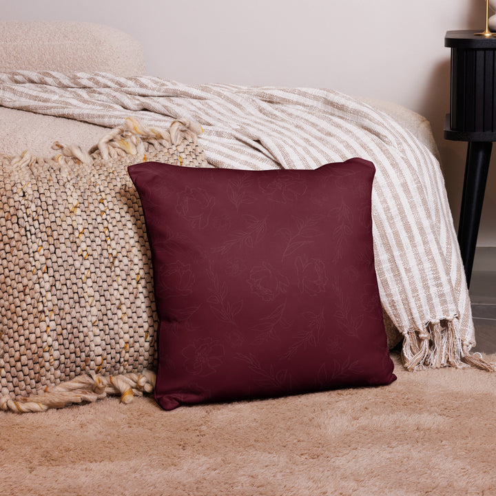 Maroon pillow with floral pattern on a textured surface
