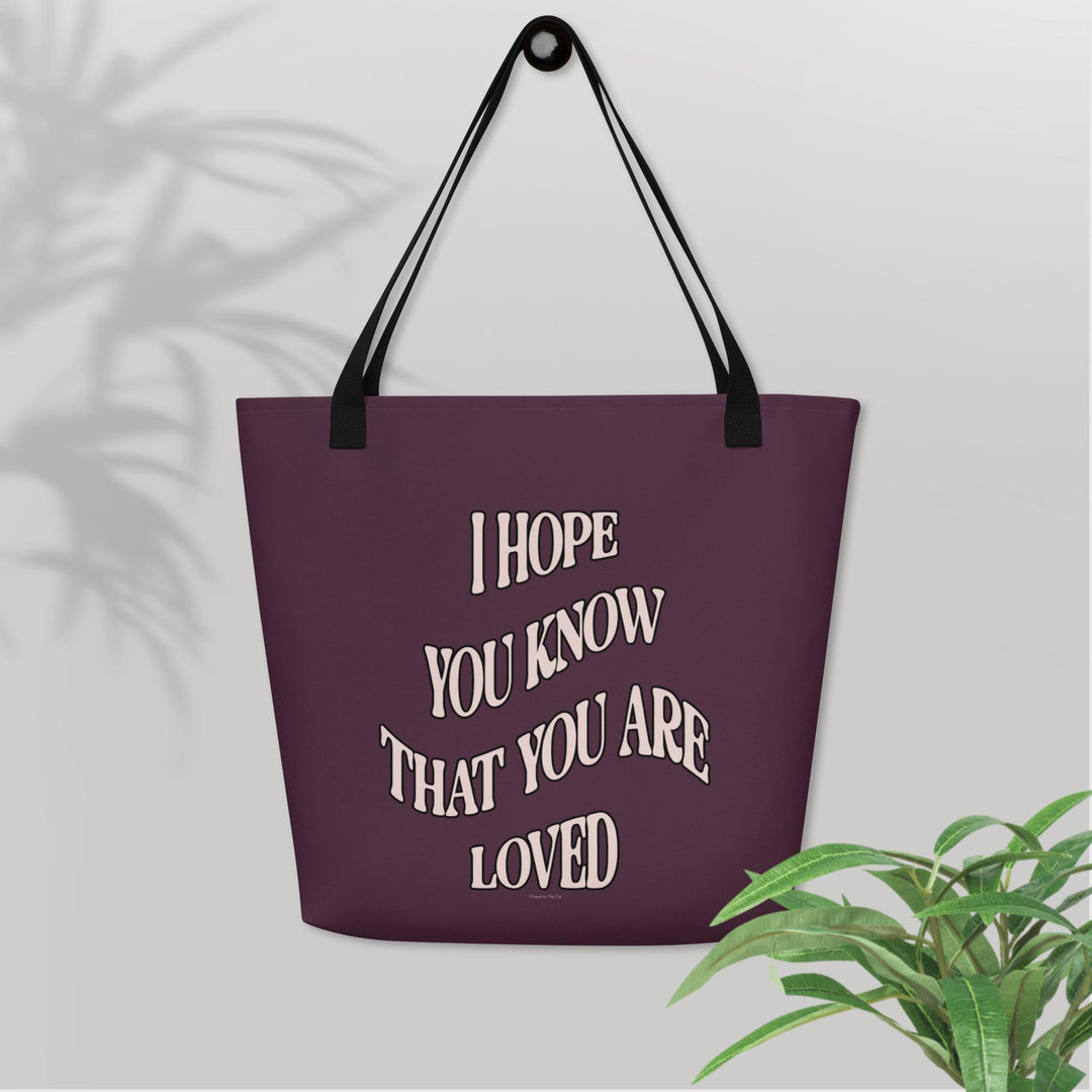 Purple tote bag with motivational quote on a light gray background