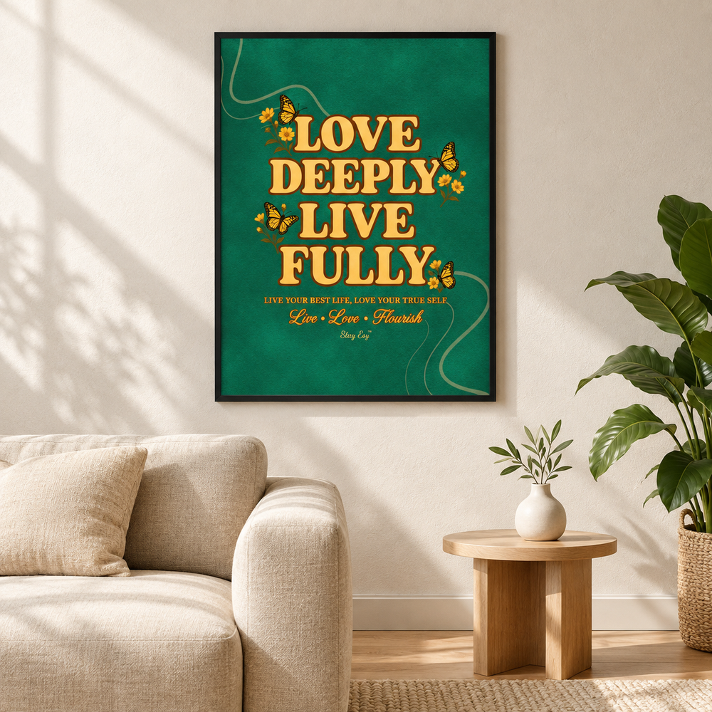 A framed wall art print with the quote 'LOVE DEEPLY LIVE FULLY' in large gold letters on a teal-green background, hanging above a beige sofa in a styled living room with a side table and plant.