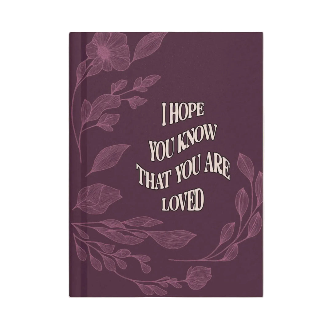 Purple notebook with floral design and text on a white background