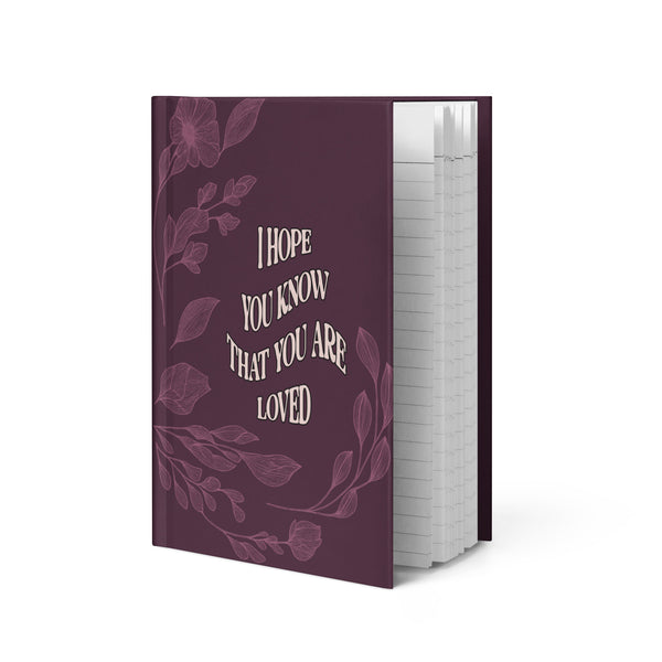 Purple notebook with floral design and text on a white background