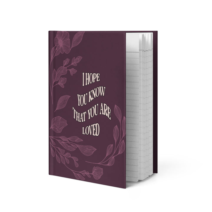 Purple notebook with floral design and text on a white background