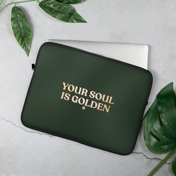 Green laptop sleeve with 'Your Soul is Golden' text on a light gray background with green leaves.