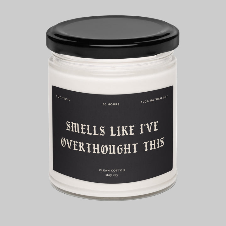 Candle jar with a black lid and humorous label on a white background