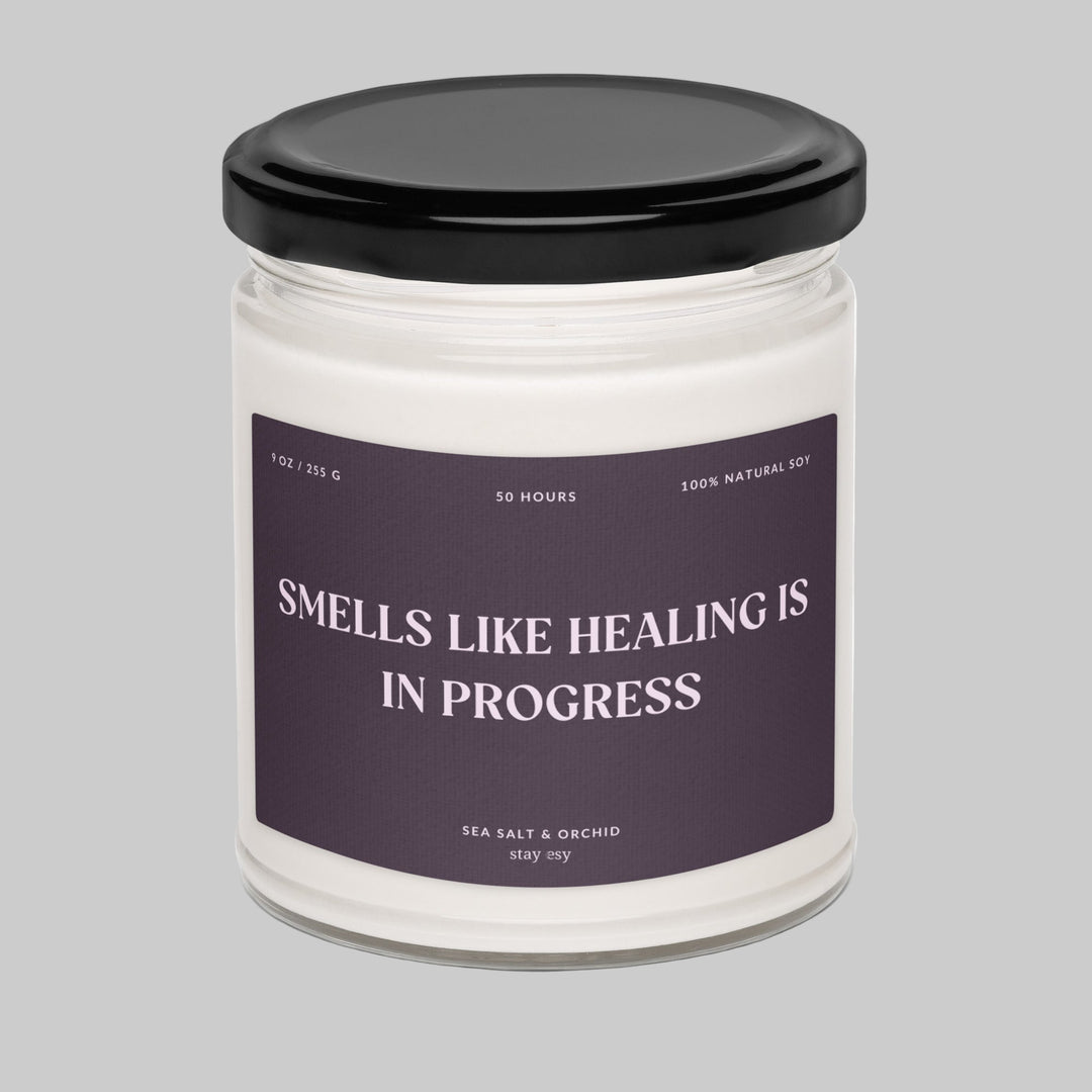 Candle jar with a black lid and purple label on a white background