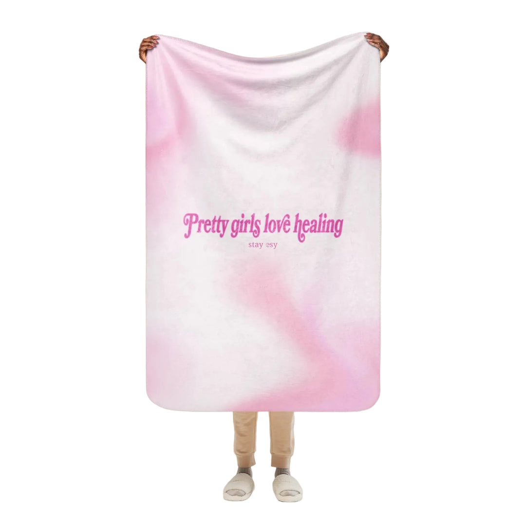 Person holding a pink and white gradient blanket with text on a white background