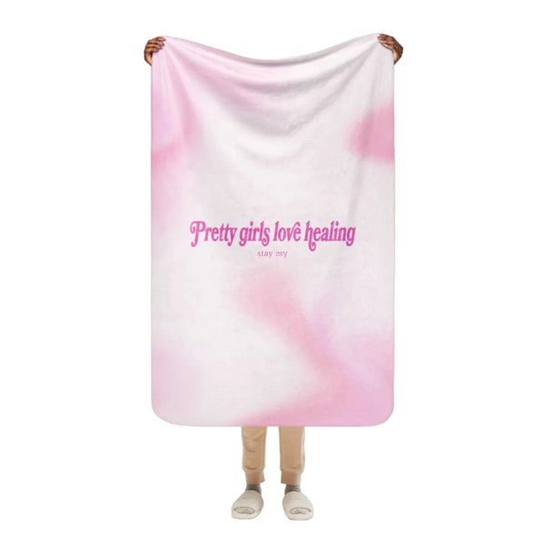 Person holding a pink and white gradient blanket with text on a white background