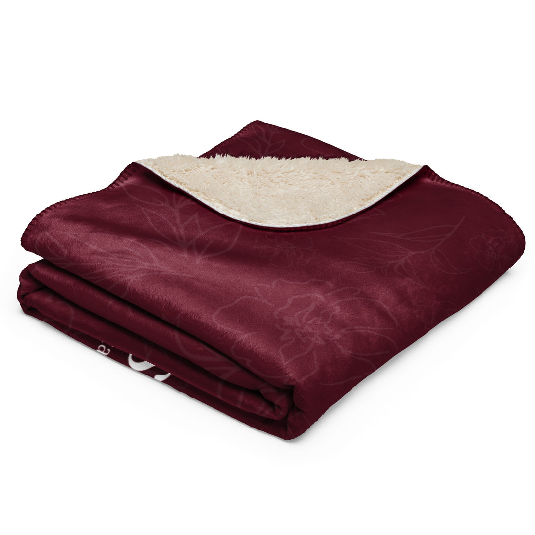 Folded black blanket with a white interior on a white background
