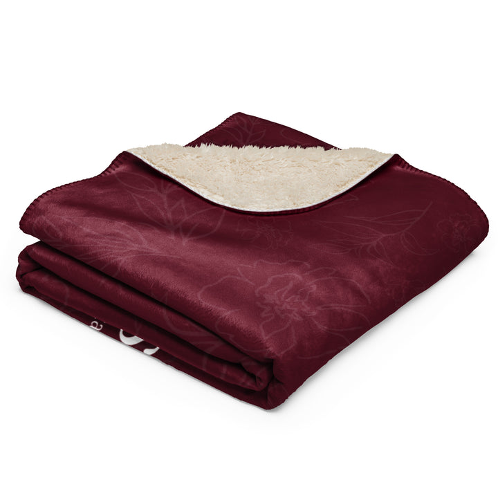 Folded black blanket with a white interior on a white background