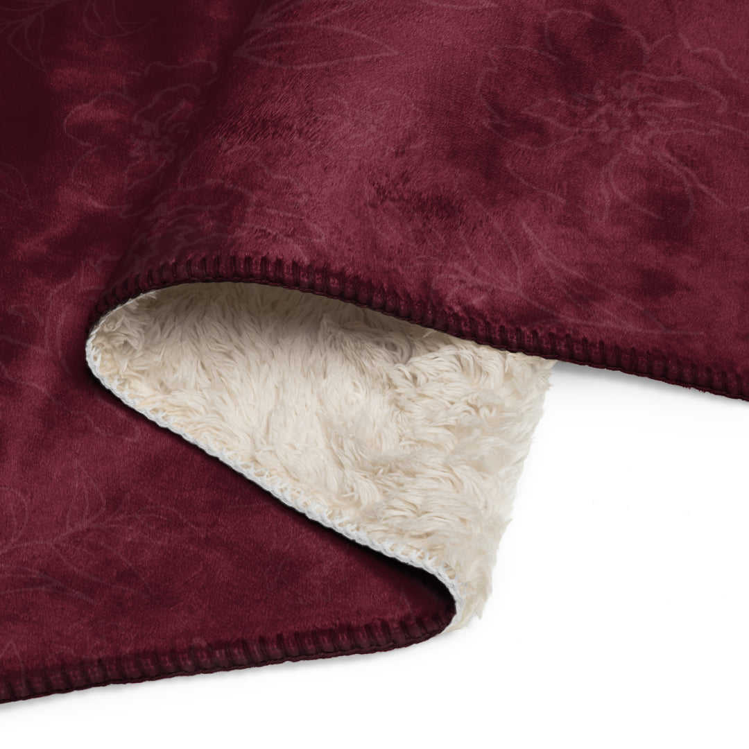 Close-up of a burgundy blanket with a beige fleece lining on a white background