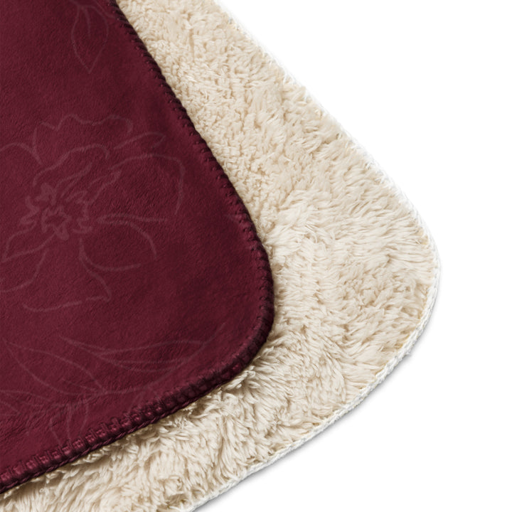 Close-up of a maroon and beige rug corner with floral pattern