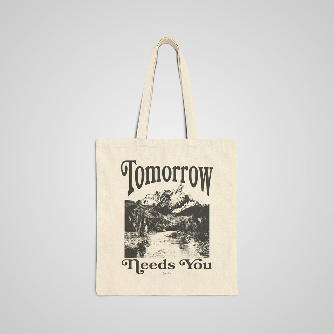 The Tomorrow Needs You Graphic Tote Bag features a bold and inspiring message on durable canvas. This large tote bag is perfect for work, school, and daily essentials.