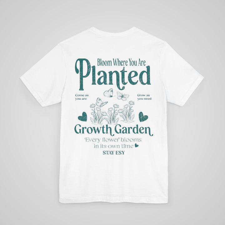 Back view of white mental health awareness graphic t-shirt with Bloom Where You Are Planted design