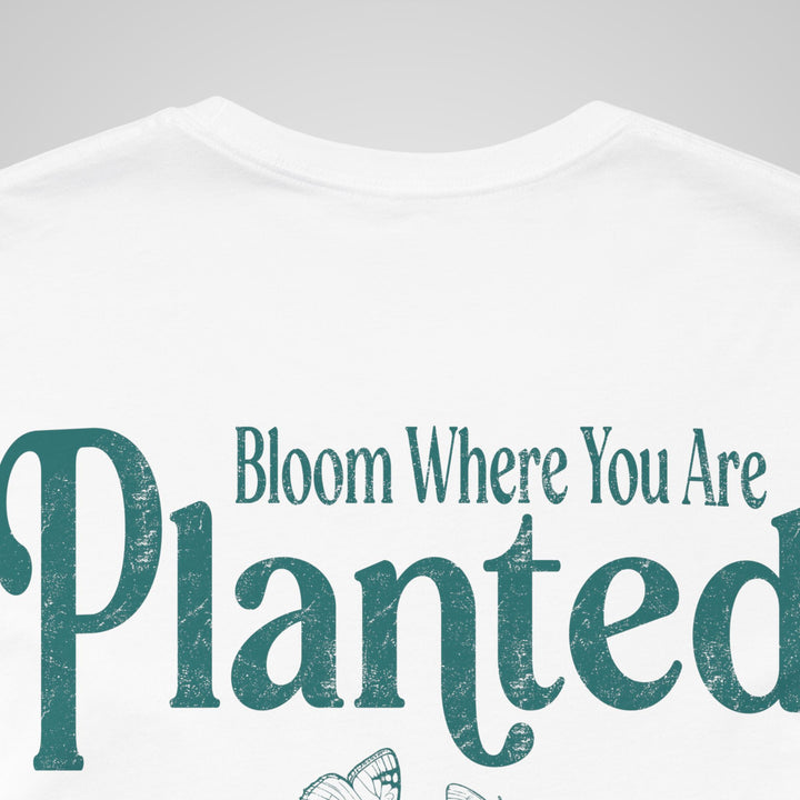 Close-up of white mental health awareness t-shirt featuring Bloom Where You Are Planted design