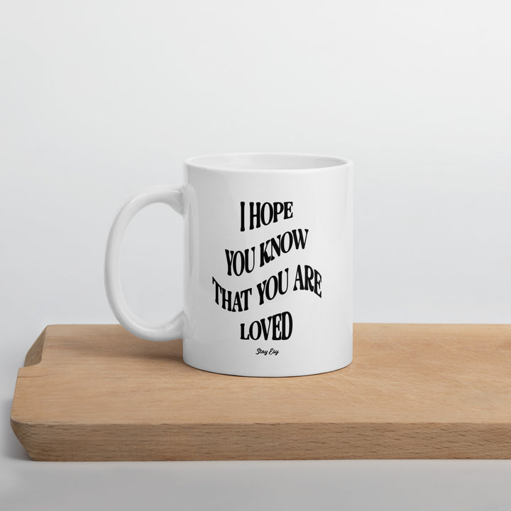 White mug with black text on a wooden surface