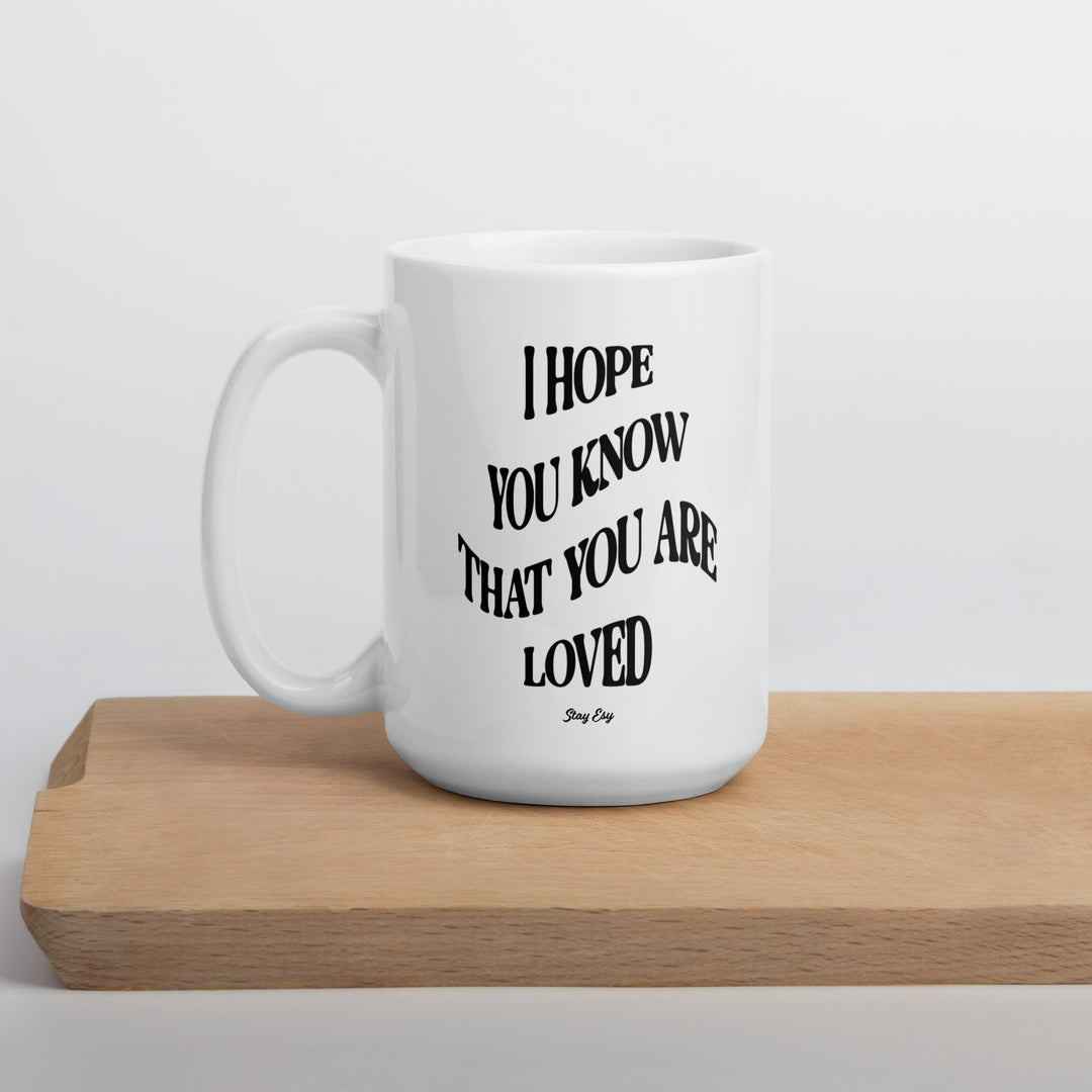 White mug with motivational quote on a wooden surface
